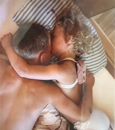A photo of Mathilde, a recipient of cochlear implants, as a young girl lying on a pillow asleep head-to-head with her father.