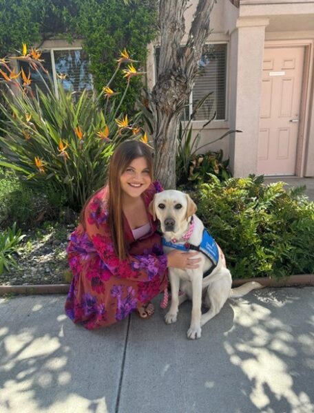 Skylynn sits with her hearing dog, and shares how she gained confidence with her cochlear implant.