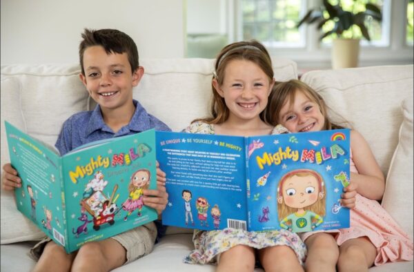 Mila smiling with her brother and sister, reading Mighty Mila